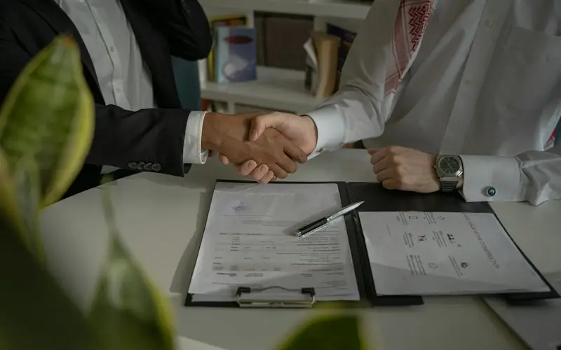 Ticaret ve şirketler hukuku: imzalanmış sözleşme üzerinde el sıkışan iki kişi